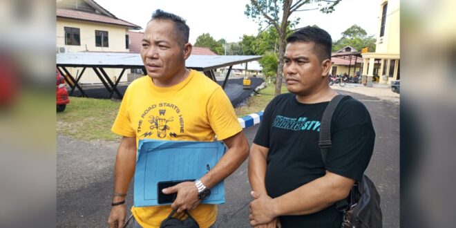 FOTO : Kades Tumbang Kaburai, Budiman Sosilo (kaos kuning, Red) saat diwawancarai wartawan lensakalteng.com di halaman Polres Melawi, Senin (25/3/2024).(sumber : wartawan beritakalteng.com)